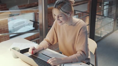 Young Caucasian Woman Having Web Call Conversation on Laptop in Office