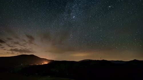 Stars with Milky Way Galaxy Moving in Starry Night Sky over Mountains in Rural Nature