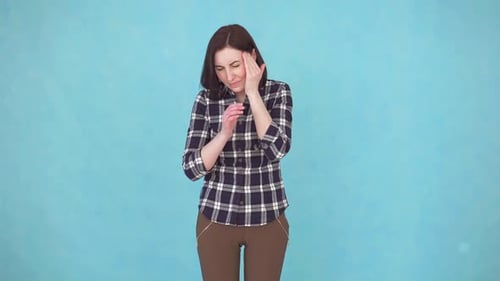 Woman Massaging Temples in Studio Setting
