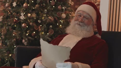 Senior Man as Santa Reads a Scroll