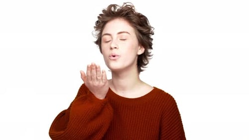 Retrato de mulher atraente com cabelo curto soprando ar beijando na câmera sendo sedutora e romântica