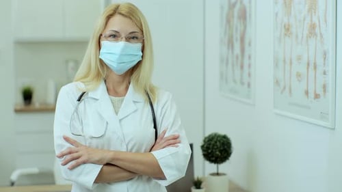 Portrait d'une femme médecin souriante portant un uniforme médical blanc et un stéthoscope regardant une caméraman