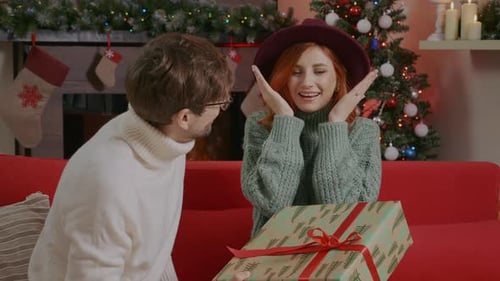 Loving Couple Exchanging Christmas Gifts at Home