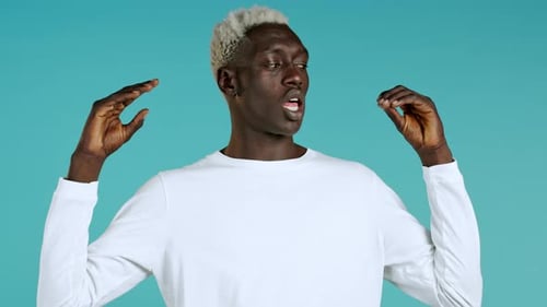 African American Bored Man Showing Bla-bla-bla Gesture with Hands and Rolling Eyes Isolated on Blue