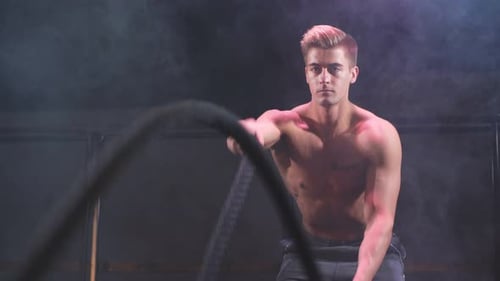 Bodybuilder Practice Effective Way To Burn Calories. Battle Rope Training in Gym