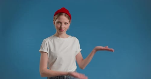 Young Woman Presenting an Invisible Object in Studio