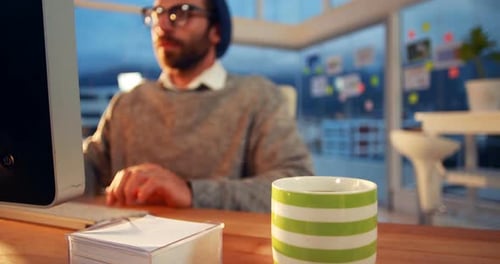 Business executive working on computer while having coffee