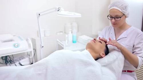 Woman Receiving a Relaxing Facial Massage in Spa