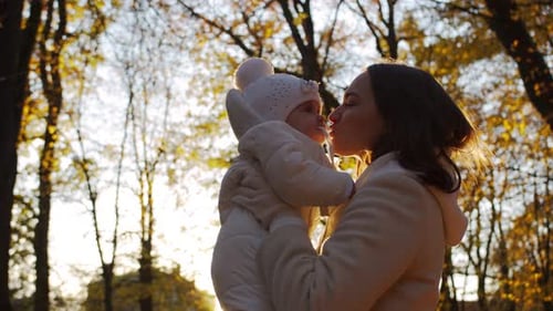 Loving Mother Holding Baby in Autumn Park