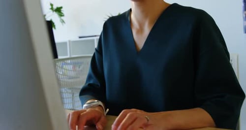 Front view of Caucasian Businesswoman working on computer at desk in a modern office 4k