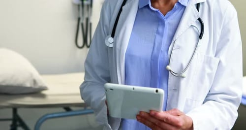 Friendly Doctor Using Tablet in Medical Office
