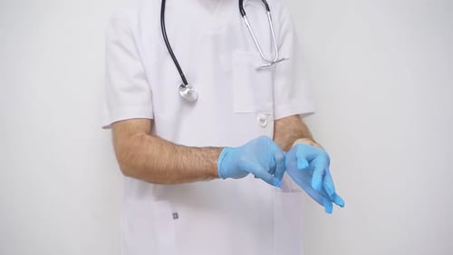 Health Professional Puts on Gloves in Medical Setting