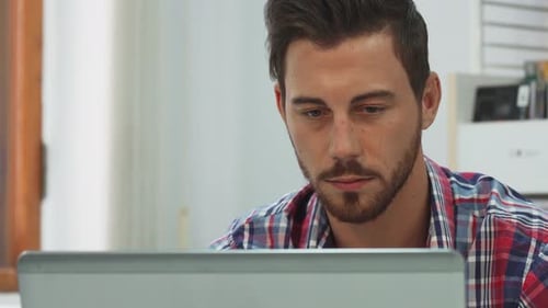 Young Adult Works at Computer in Office