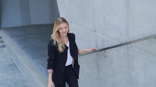 Cheerful Businesswoman on Staircase Outside Modern Building