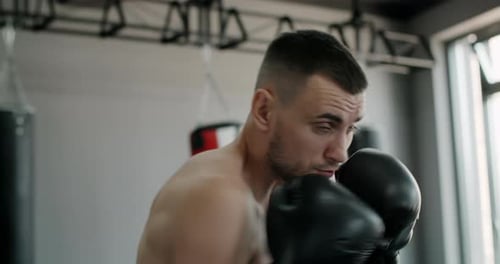 Kickboxer in Boxhandschuhen macht Schattenboxen und trainiert im Boxing Club Fighter Man kämpft mit
