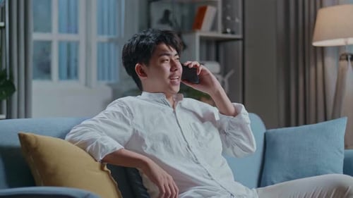 Young Man Relaxing on Couch Talking on Phone