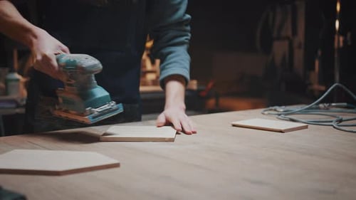 The Hands of a Male Carpenter in His Garage Doing Sanding of Woodwork