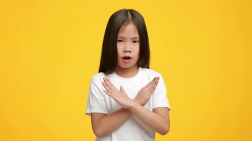 Serious Asian Kid Girl Gesturing Stop Crossing Hands Yellow Background
