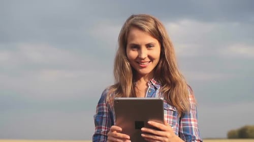 Woman Using Tablet in Rural Golden Wheat Field