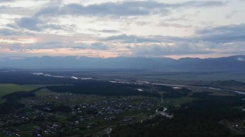 Luftaufnahme von Tal- und Landhäusern unter blauem Himmel bei Sonnenuntergang