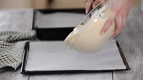 Hands Pouring Batter onto Baking Sheet