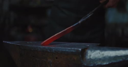 Professional Blacksmith Shaping Future Knife By Hammer and Anvil in Forge Closeup View Prores