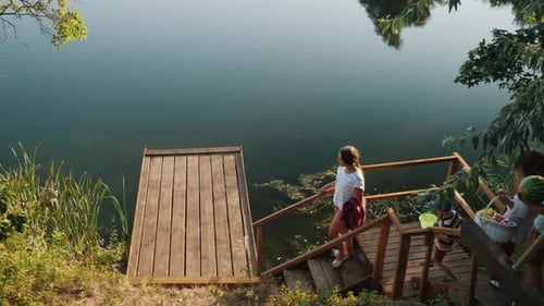 Family Down To a Wooden Pier for a Picnic