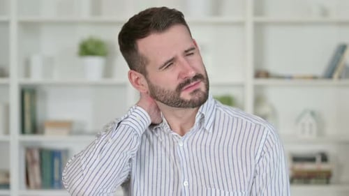Man Experiences Neck Pain, Rubs Neck in Discomfort