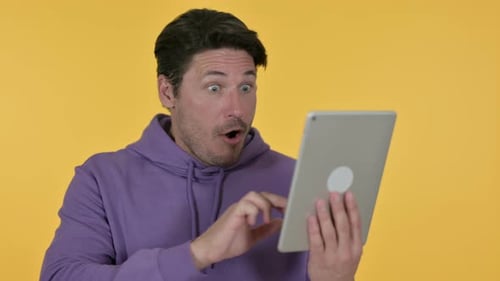 Man Celebrating on Tablet, Yellow Background