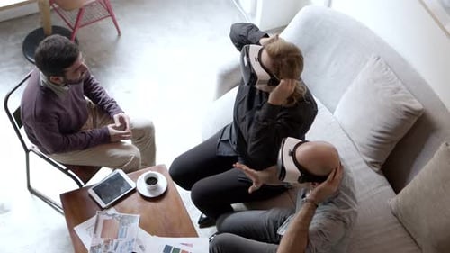 Top View of Smiling Landscape Designer Showing Examples of His Work with Help of VR Headsets