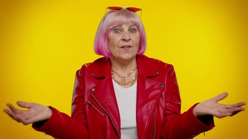 Confused Senior Woman Talking on Yellow Background