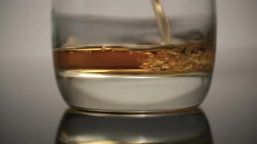 Amber Liquid Pouring into Clear Glass