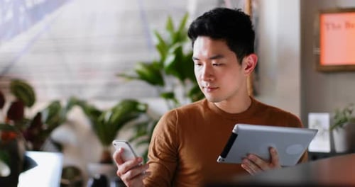 Young Adult Using Phone and Tablet Indoors