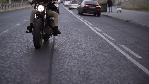 Motociclista irreconhecível dirige uma bicicleta na cidade