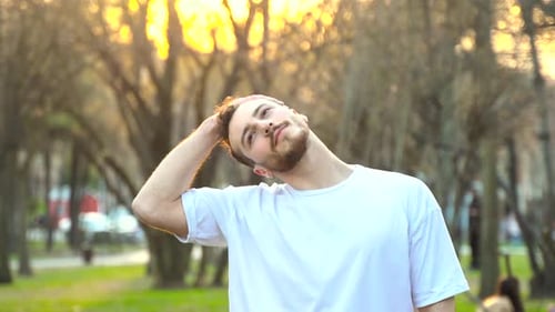 Man Stretches Neck in a Park
