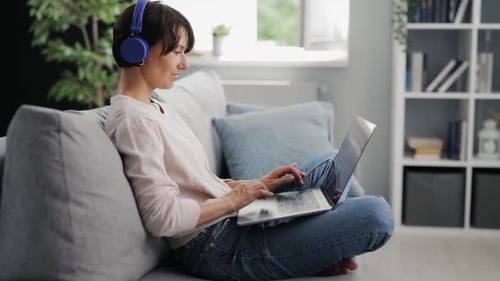 Woman Working on Laptop Computer with Headphones
