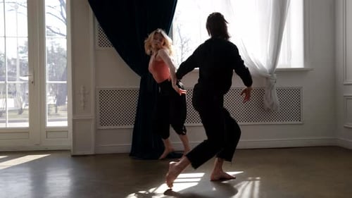 Two Dancers Performing Contemporary Dance in Bright Studio