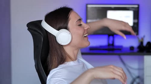Woman Relaxing with Headphones in Computer Chair