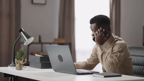 Young Entrepreneur is Calling By Mobile Phone Working in Modern Office or Home Communication with