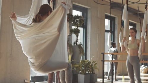 Young Adults Practicing Yoga in a Bright Studio