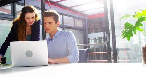 Young Professionals Collaborating on a Laptop in Office