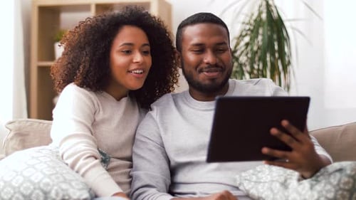 Young Couple Relaxing at Home Using Tablet