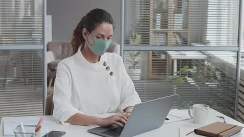Woman Wearing Face Mask Working on Laptop