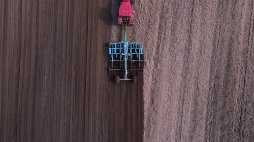 Tractor Plows Ground on Cultivated Farm Field