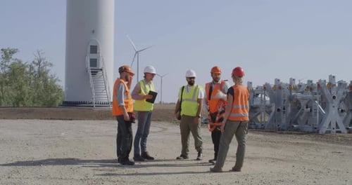 Engineers Discuss Wind Turbine Construction on a Sunny Day