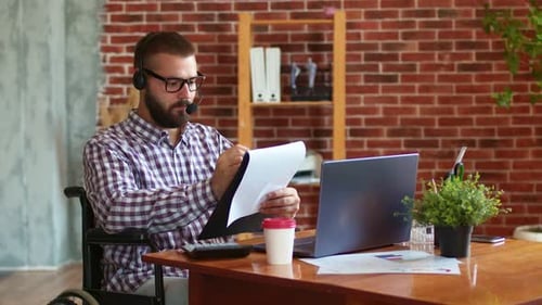 Man in Wheelchair Working at Office Desk