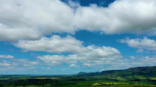 Aerial View of Green Fields and Cloudy Sky
