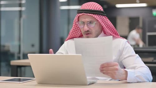 Frustrated Man Reading Document in Modern Office