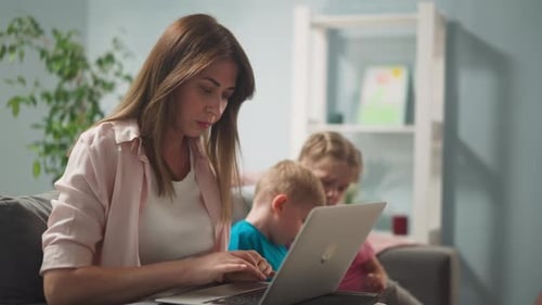 Junge Frau im hellen Raum arbeitet zu Hause aus der Ferne am Laptop