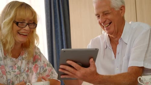 Senior Couple Using Tablet Together, Laughing